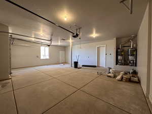 Garage featuring water heater, a garage door opener, and gas water heater