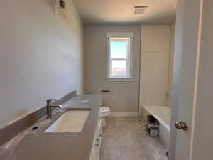 Full bathroom featuring toilet, vanity, bathtub / shower combination, and tile patterned floors