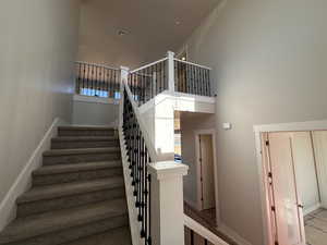 Staircase featuring a high ceiling