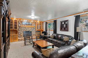 Carpeted living room with a textured ceiling and a fireplace