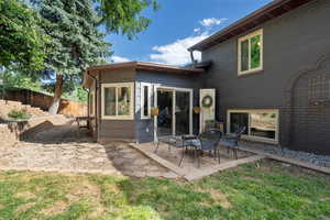 Rear view of house with a yard and a patio