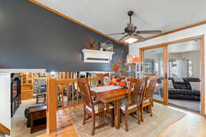 Dining area featuring light wood-type flooring, a textured ceiling, and ceiling fan