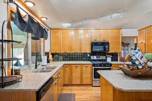 Kitchen featuring a textured ceiling, light wood-type flooring, sink, and appliances with stainless steel finishes