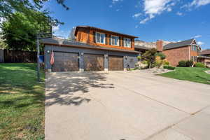 View of front of house with a front yard and a garage