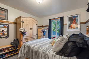 Carpeted bedroom with a textured ceiling