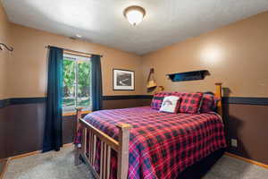 Bedroom featuring a textured ceiling and carpet