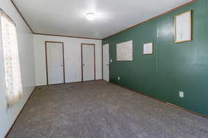 Unfurnished bedroom featuring carpet and ornamental molding