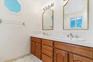 Bathroom with tile patterned flooring, backsplash, and vanity