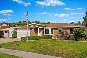 Ranch-style house featuring a front lawn and a garage