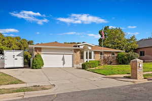 Ranch-style house with a garage and a front lawn