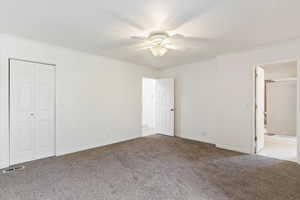 Unfurnished bedroom featuring carpet flooring, ornamental molding, ceiling fan, and ensuite bathroom