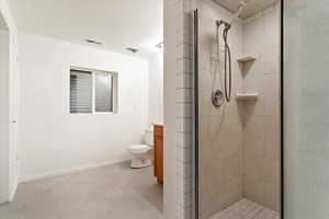 Bathroom featuring vanity, a shower with shower door, toilet, and a textured ceiling