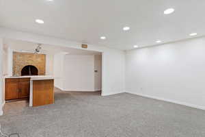 Unfurnished living room featuring a fireplace and carpet flooring