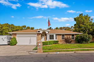 Single story home with a garage and a front yard