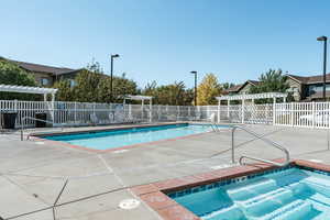 View of swimming pool with a pergola and a hot tub