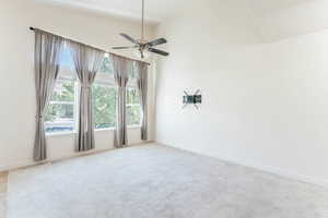 Carpeted empty room with ceiling fan