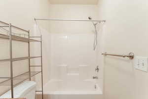 Bathroom featuring shower / bathtub combination and toilet