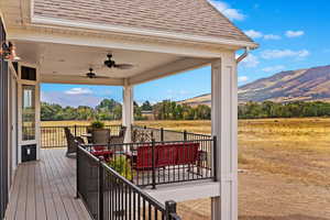 Wooden terrace featuring a mountain view, a rural view, and ceiling fan