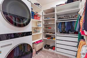 Spacious closet featuring light colored carpet