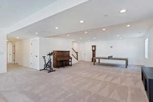 Rec room with light colored carpet and a textured ceiling