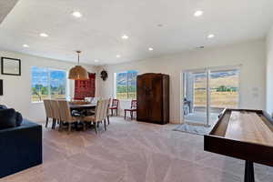 Carpeted dining room with a textured ceiling and plenty of natural light