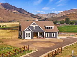 View of front of home with covered porch, a mountain view, and a rural view