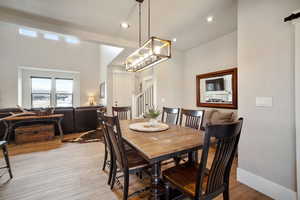 Dining space featuring light wood-type flooring and a notable chandelier