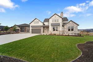 View of front of house featuring a front lawn and a garage