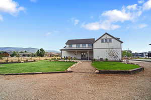 View of front of home with a mountain view and a front yard