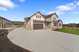 View of front of property featuring a garage and a front lawn