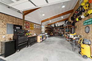 Garage featuring electric panel and a workshop area