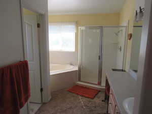 Bathroom featuring vanity and separate shower and tub