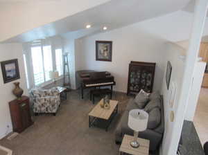 Living room featuring vaulted ceiling and light colored carpet