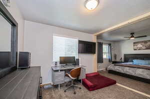 Bedroom featuring a textured ceiling, dark carpet, and ceiling fan