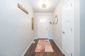 Doorway to outside with dark hardwood / wood-style floors and a textured ceiling