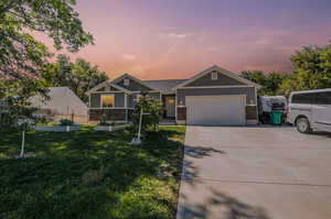 View of front of home featuring a lawn and a garage