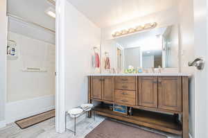 Bathroom featuring vanity, wood-type flooring, and bathing tub / shower combination