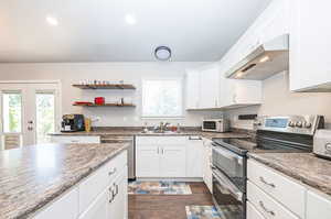 Kitchen featuring appliances with stainless steel finishes, sink, white cabinets, and dark hardwood / wood-style floors