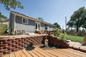 Wooden deck featuring a lawn and a patio