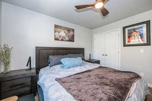 Bedroom featuring a closet, ceiling fan, carpet floors, and a textured ceiling