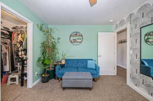 Living area featuring a textured ceiling and carpet