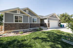 Craftsman inspired home with a garage and a front yard