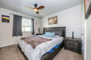 Bedroom with a textured ceiling, ceiling fan, and light carpet