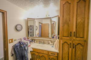 Bathroom featuring a textured ceiling and vanity