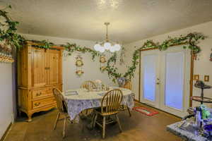 Dining room featuring a textured ceiling and an inviting chandelier