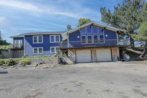 View of front of house with a garage and a deck