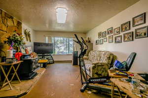 Interior space featuring a wood stove and a textured ceiling