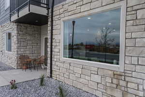 View of exterior entry featuring a patio and a balcony