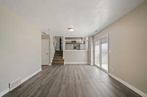 Unfurnished room featuring dark hardwood / wood-style flooring and a textured ceiling