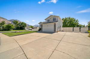 Exterior space with a mountain view, a lawn, and a garage